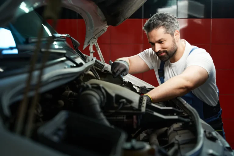 Professional car service technician fixing the engine and possible problem.